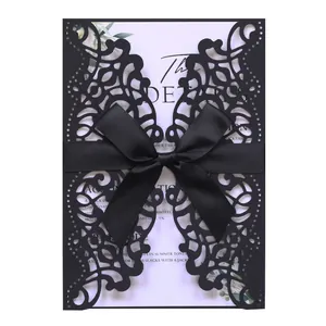 Κομψή μαύρη πρόσκληση γάμου laser-cut με σατέν φιόγκο και εσωτερικό με φλοράλ σχέδιο