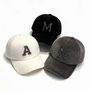 Detail view of faux mink fur baseball caps with sparkling rhinestone letters A, M, and N