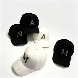 Detail view of warm mink fur winter baseball caps with sparkling rhinestone letters.
