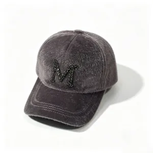 Detail of grey faux fur baseball cap with sparkling rhinestone letter M ornament