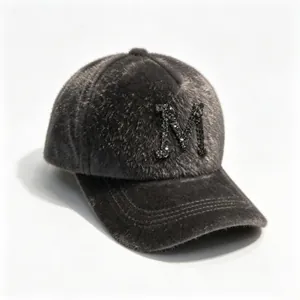 Close-up of a grey faux mink fur baseball cap featuring a sparkling rhinestone letter M