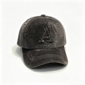 Detail showing a fuzzy dark grey winter baseball cap with a sparkling rhinestone letter A