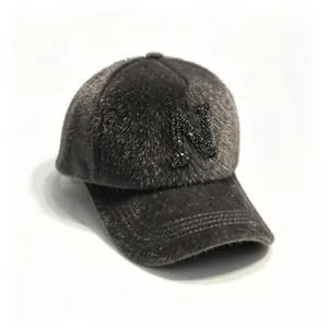 Close-up detail of grey faux mink fur baseball cap with a sparkling rhinestone letter N.