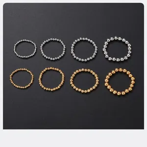 Detailed view of elastic stainless steel bead bracelets in gold and silver finishes