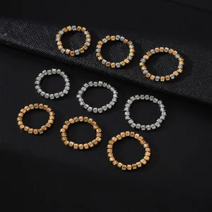 Detailed view of multiple elastic beaded rings in gold and silver stainless steel