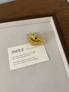 Close-up of vintage gold-tone evil eye ring with sparkling crystals on a display card