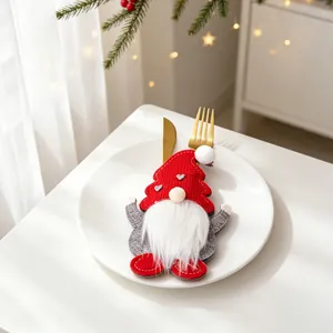Detailansicht eines Weihnachtsgnom-Besteckhalters auf einem weißen Teller mit Goldbesteck