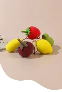 Close-up of fruit-shaped makeup sponges featuring strawberry, lemon, and mango designs