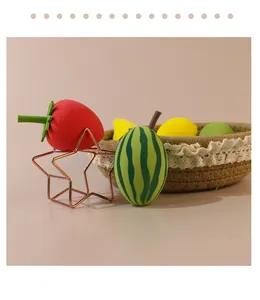 Close-up of cute strawberry and watermelon shaped makeup sponges displayed in a basket