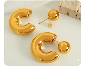 Macro view of chunky gold C-shaped hoop earrings featuring a polished ball-back design