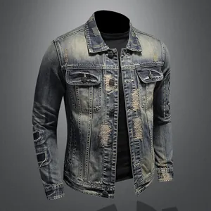Close-up of men's vintage washed blue denim jacket featuring heavy distressed ripped patches