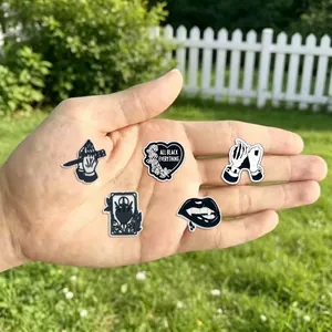 Gothic style black and white shoe charms for clogs presented on a hand 80-100 chars