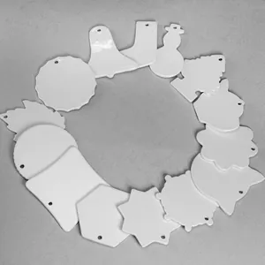 Set of white sublimation ceramic ornaments in various shapes arranged in a circle.