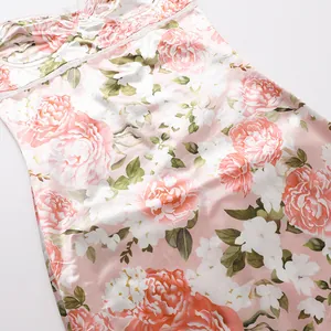 Detailed close-up showing the pink floral peony print on smooth satin fabric camisole dress