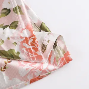Close-up detail of the fine stitching and hem on a pink floral satin slip dress.
