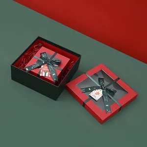 Elegantes cajas de regalo de Navidad con ventana, lazo verde y etiquetas decorativas.