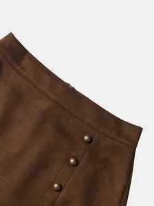 Detailansicht eines braunen Wildleder-Minirocks mit Vintage-Metallknöpfen und hohem Bund