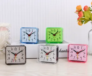 Close-up view of colorful mini square alarm clocks with simple analog quartz display