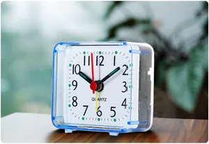 Close-up detail of a minimalist blue transparent square mini quartz alarm clock for bedside table