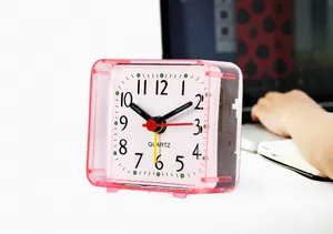 Close-up of a pink square mini quartz alarm clock on a desk