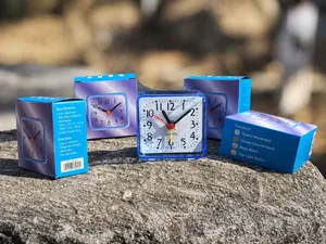 Compacte blauwe vierkante kwartswekker met witte wijzerplaat en blauwe verpakking