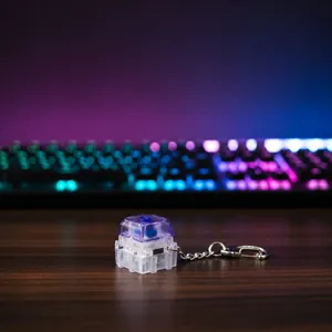 Macro view of a glowing mechanical keycap keychain with a transparent purple shell