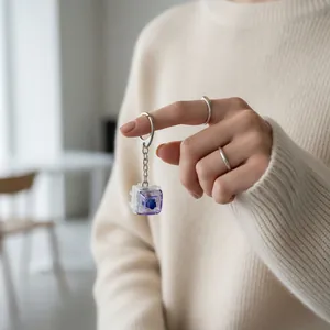Close-up of a purple mechanical switch fidget keychain held by a model's hand