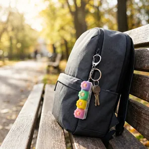 Macro detail of cat paw mechanical button stress relief keychain hanging on a backpack