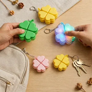 Detail of colorful four-leaf clover LED stress relief keychains on a wooden table.