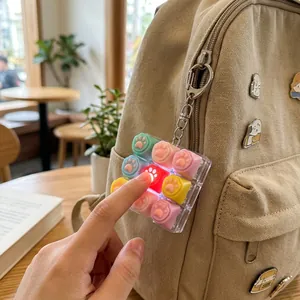 Détail d'un jouet anti-stress en forme de patte de chat qui s'allume sur un sac à dos