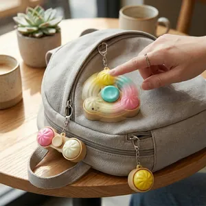 Image d'un porte-clés fidget en forme de brioche tournant sur un sac à dos gris