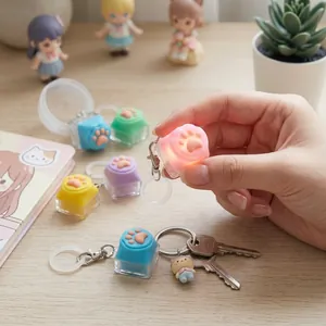 Porte-clés de touche de clavier en forme de patte de chat rose brillant dans la main