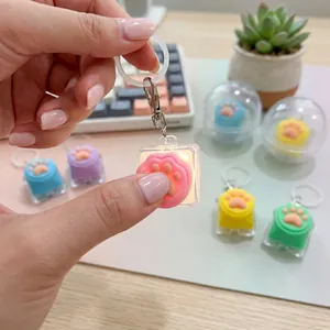 Gros plan d'un porte-clés lumineux en silicone en forme de patte de chat dans une main