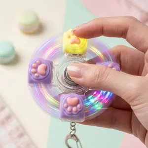 Gros plan d'un hand spinner mécanique patte de chat lumineux tourné par une main