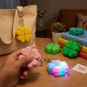 Colorful four-leaf clover light-up fidget keychain glowing on a wooden table
