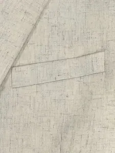 Detailansicht der Leinentextur und Tasche eines beigen, schmal geschnittenen Herrenanzugs