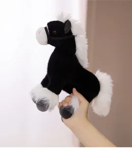 Detailed side view of a realistic black and white plush horse toy being held by hand