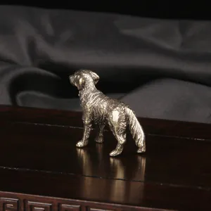 Macro view of an antique brass sheepdog figurine standing on a dark wooden base