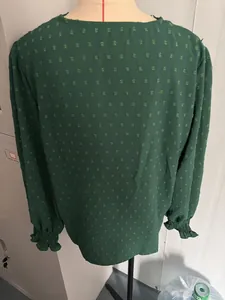 Back view of a green long-sleeved blouse with Swiss dot textured fabric details