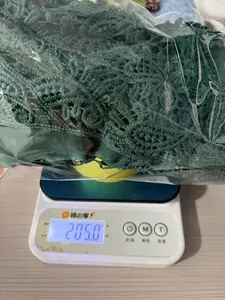 Detailed weight measurement view of dark green lace top showing 205.0g on electronic scale