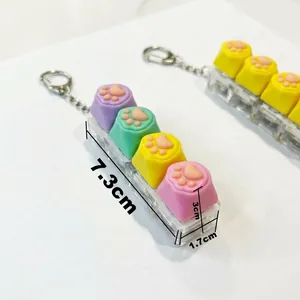 Cat paw fidget keychain featuring four colorful keycaps and clear mechanical base