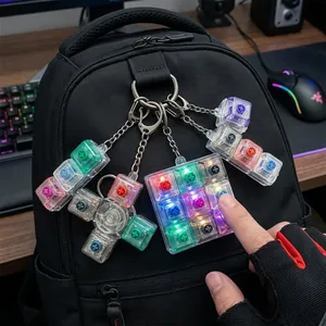 Leuchtender mechanischer Tasten-Schlüsselanhänger als Fidget-Spielzeug am Rucksack.
