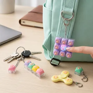 Gros plan d'un porte-clés fidget patte de chat brillant sous la pression d'un doigt