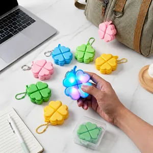 Detail view of glowing four-leaf clover keychain with mechanical click feel for stress relief