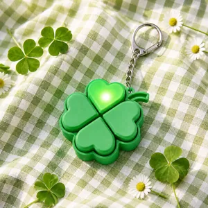 Detail view of a green four-leaf clover fidget keychain with glowing LED light effect