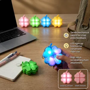 Detail view of glowing four-leaf clover fidget keychain with mechanical switch feel