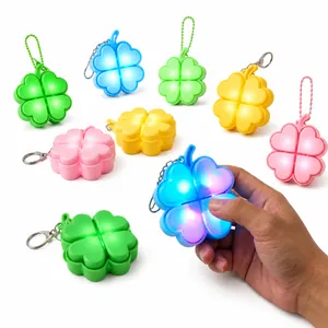 Close-up of glowing four-leaf clover fidget keychain with mechanical tactile feel.