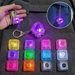 Detailed view of mechanical keyboard keycap fidget keychains in various LED colors