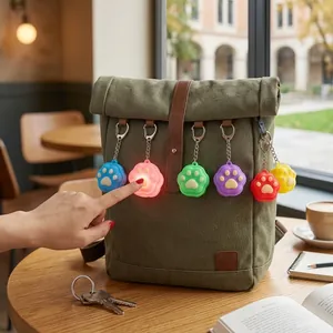 Detailansicht bunter leuchtender Katzenpfoten-Schlüsselanhänger an einem Rucksack.