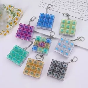 Variété de porte-clés colorés 3x3 de touches de clavier mécanique sur bureau blanc